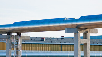 pipelines on concrete supports, in the background is a factory building