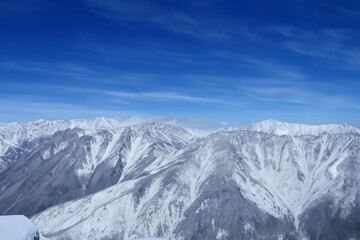 A mountain range with snow on it. Nature and mountains in the snowy sky. Snowy mountains sky nature winter snow. Snow and clouds in the mountains lifestyle in winter.