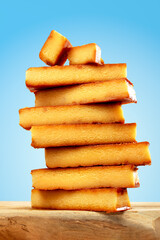 Closeup shot of stacked toasted egg yolk turron bars, macro texture, hero shot on wooden podium