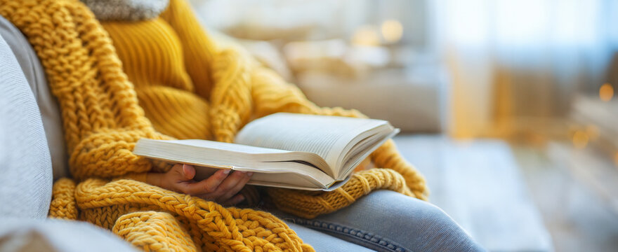 Cozy autumn reading in a warm yellow sweater on a lazy afternoon sunday