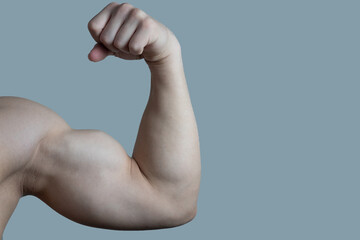 Bodybuilder's hand on a light background. The athlete is ahead of the competition. Drying. Relief and sculpted arm muscles. Healthy lifestyle concept. Muscles.