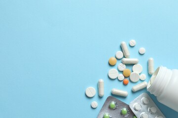 Various pills and capsules on a color background
