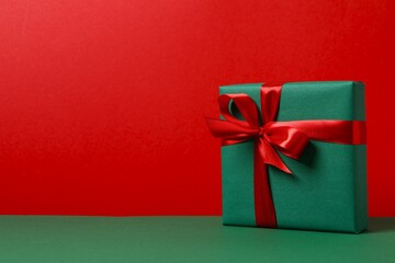 Beautiful gift box tied with bow on color background 
