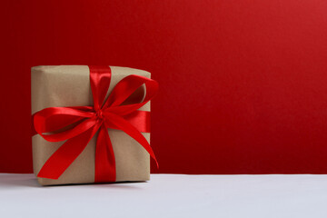 Beautiful gift box tied with bow on color background 