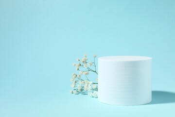 Podium and white gypsophila flowers on a colored background