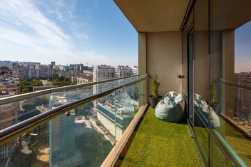 Panoramic view from the balcony with artificial grass and glass railing.