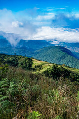 Breathtaking mountain view overlooking lush green valleys cloudy sky landscape photography high altitude nature's beauty