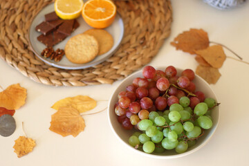 Pumpkins, various food and drinks, fall decorations, books and candles on the table. Fall hygge at home. Selective focus.