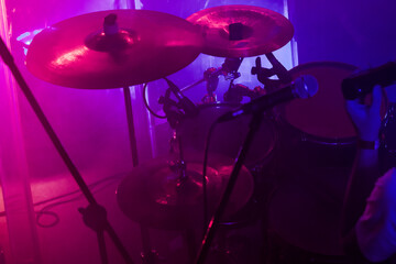 A band drum set is in purple stage lights, close-up photo