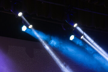 Beams of scenic spot lights in smoke over dark background