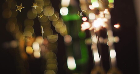Sparkler glowing with golden star image over blurred festive lights background
