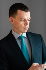 Successful smiling ambitious caucasian european businessman lawyer in suit standing in light office with laptop and phone