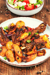 Sliced barbecue pork ribs and potatoes.