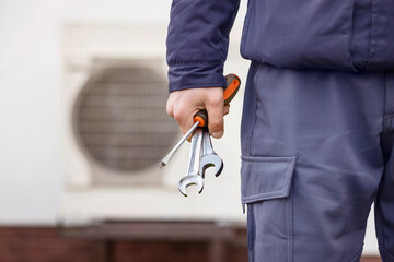 Heat Pump Install Service. Worker Hand with Tools Installing Heat Pump System or Conditioner.