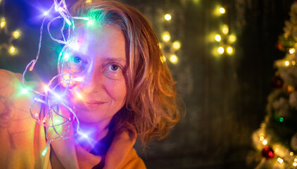 woman hanging up colorful Christmas lights