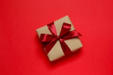 Beautiful gift box tied with bow on color background 