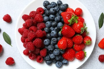 Different fresh ripe berries in bowl on the table