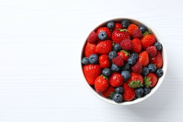 Different fresh ripe berries in bowl on the table