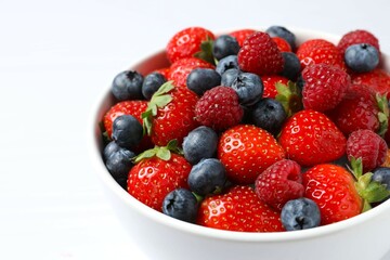 Different fresh ripe berries in bowl on the table
