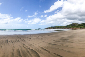 A Stunningly Serene Beach Landscape with Gentle Waves and a Beautiful Blue Sky Hovering Above It