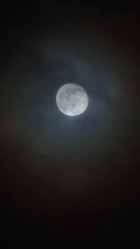 Blue Full Moon in the night sky with foggy clouds. Real video shooting of the Moon close up