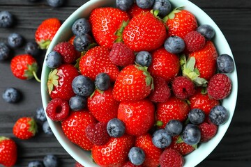 Different fresh ripe berries in bowl on the table