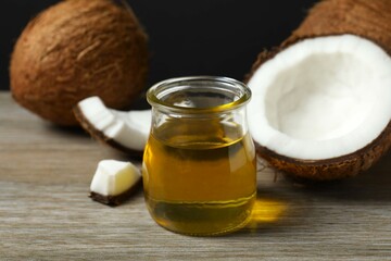 Jar of coconut oil on wooden background