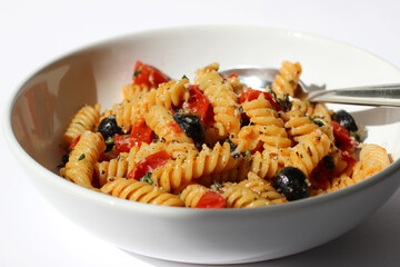Fusilli Pasta with Tomato Sauce, Olives, Pepper and Cheese. Cooking Traditional Italian Food.