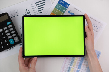 a tablet with a green screen in the hands of a girl