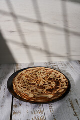 Stack of thin crepes on a wooden board