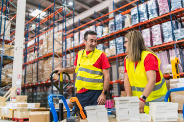 Warehouse workers handling goods using pallet jack in logistics center