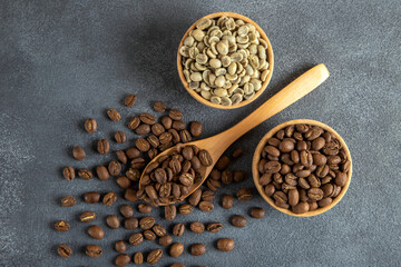 Green coffee with roasted coffee beans on gray background