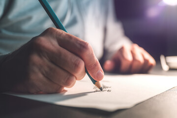 Closeup of male hand with graphite pencil drawing on paper