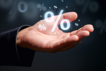 Interest rate, dividend and discount concept. Closeup of male hand with percent symbol