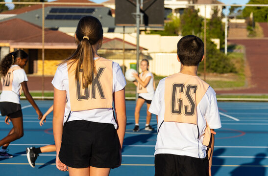 children at netball training on blue playing surface and