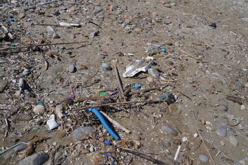 massive pile of trash on a sand beach 
