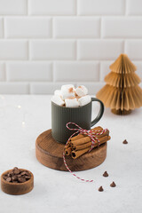 New Year cocoa mug with marshmallows and cinnamon on round board