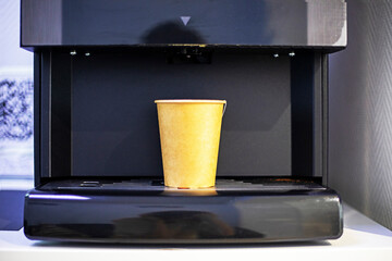 vending machine with a disposable, recyclable cardboard cup containing a hot drink. Ecology of the environment