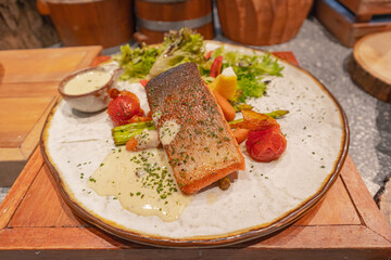 Grilled salmon with lemon cream sauce and mixed garden salad