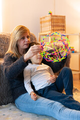 Mother and son playing with a colorful expanding sphere toy at home