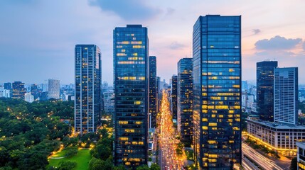 Aerial view of modern skyscrapers at dusk with city lights glowing.