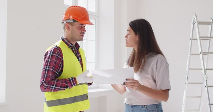 Go away. Builder sacked by angry woman house owner. Young shouting unsatisfied female client enraged by remodeling problem fires male worker, crumples paper construction plan and throws it in his face