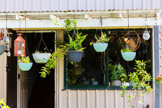 Hanging pot plant garden on porch of house with open door