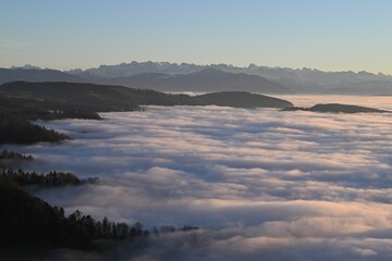 Fog-covered valley with distant mountain peaks.
