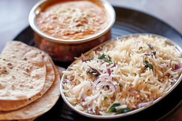 Delicious Indian thali with fluffy basmati rice, creamy curry, and chapati, showcasing the vibrant and aromatic flavors of Indian home-cooked meals.