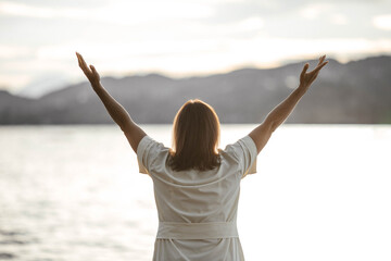 Caucasian mature female enjoying a peaceful lake view at sunset
