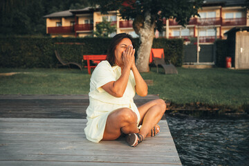 Hispanic female adult enjoying lakeside summer evening in casual outfit