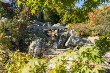 Krasnodarsky Japanese Garden. Picturesque artificial waterfall built from huge natural stones. Water falls into artificial rock bed. Banks are fortified with huge natural stones and boulders.