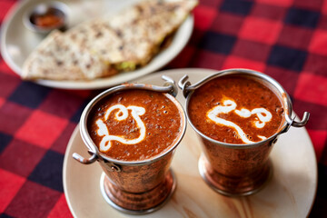 Authentic Indian thali featuring creamy Dal Makhani, refreshing yogurt dip, and crispy naan bread, highlighting the rich and flavorful vegetarian cuisine.