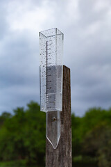 Close-up view of a rain gauge on a field pole